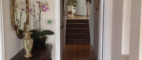 View from front door to 4 carpeted stairs, handrail, 2 bedrooms & main bathroom 