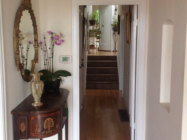 View from front door to 4 carpeted stairs, handrail, 2 bedrooms & main bathroom 