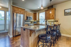 Warm wood flooring and vaulted ceilings welcome you into the heart of the home