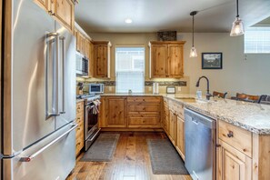 Modern kitchen with stainless steel appliances & everything you need to cook in