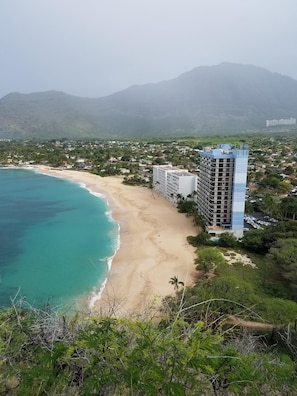 Hawaiian Princess is tall building with blue trim, located on secluded beach.