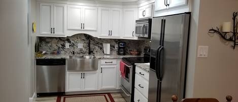 granite countertops, stainless steel appliances and farmhouse sink