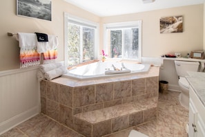 Jetted tub in the full bathroom. Windows overlook the creek.