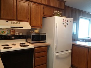 Large stove, refrigerator with large deep freezer, and bran new microwave.
