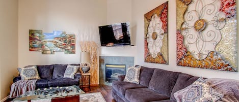 Main level living room with fireplace and 60" TV