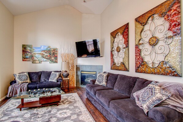 Main level living room with fireplace and 60" TV