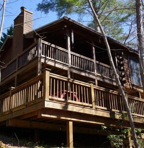 this is a view from the ground. It is a one level cabin with a ground level deck