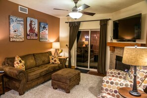 living room with great couch and ottoman with sliding doors to balcony.