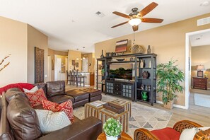 After a long day, curl up on the plush sofa, put your feet on the ottomans, and binge watch on your 55" Smart TV