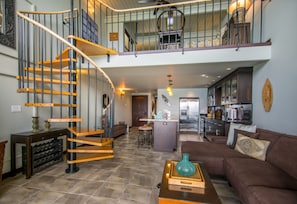 The open, spiral staircase ascends to the Master Suite.
