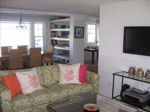 Living Room with flat screen and view into dining area and study behind shelves.