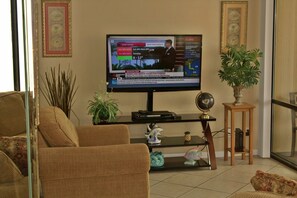 LARGE TV IN THE LIVING ROOM AND COMFORTABLE CHAIR