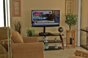 LARGE TV IN THE LIVING ROOM AND COMFORTABLE CHAIR