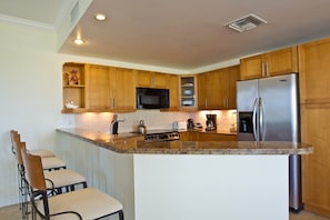 Fully equipped kitchen with stainless steel appliances, fridge & oven