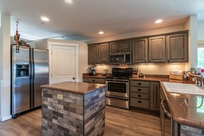 Chefs kitchen with large pantry and granite countertops.