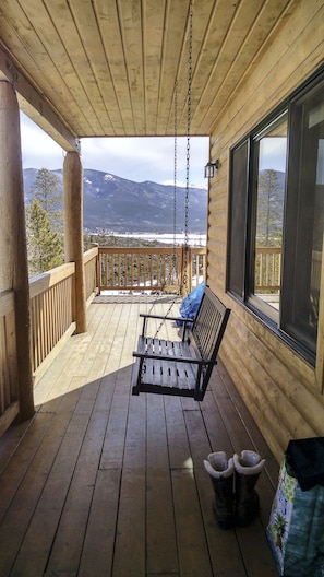 Porch swing on the covered deck offers mountain and lake views