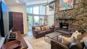 BC West Condo #31 living room with wood fireplace and balcony w/ gas BBQ grill