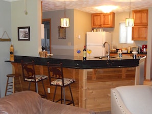 Bright open kitchen with granite countertops and ceramic tile floors.