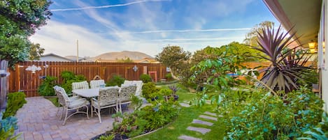 Stone patio table surrounded by lush garden and our signature Melaleuca tree.