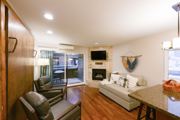 Cozy Living space with Fireplace and HDTV, plus Private Balcony with slope views