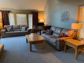 Main floor living room with smart TV, piano and gas fireplace