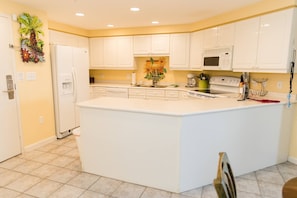 Enter into kitchen. New appliances, fully stocked, everything you need to cook.