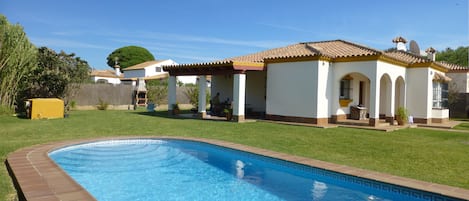 Villa with view of private pool and wrap around garden.