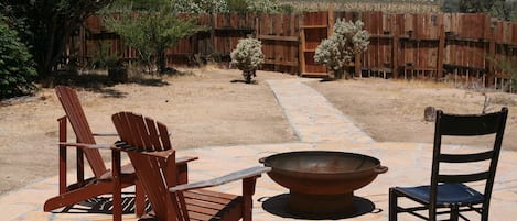 Spacious back yard with wood burning fire pit.