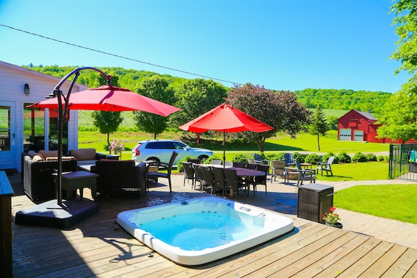 The backyard features a deck with lounge seating a jacuzzi, open year-round. 