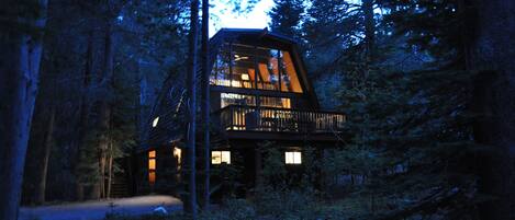 The Aloha Cabin at sunset surrounded by trees, with level driveway