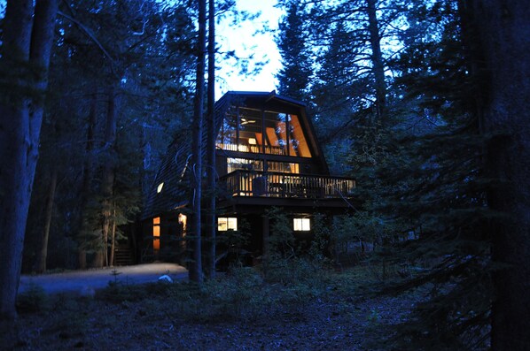 The Aloha Cabin at sunset surrounded by trees, with level driveway