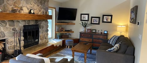 Cozy living area with wood burning fireplace and comfortable queen plus pullout.