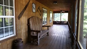 Wrap around screen porch with rocking chairs, tables and beautiful views