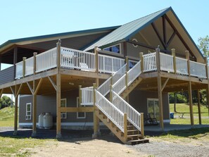 Front view of lodge showing multiple decks, beams and stairs