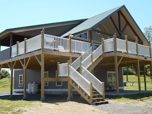 Front view of lodge showing multiple decks, beams and stairs
