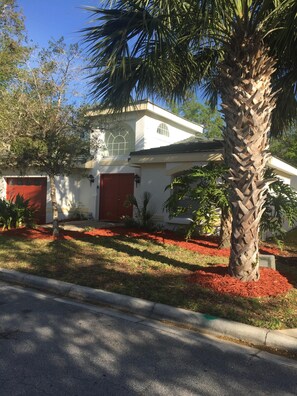 Front of villa with tropical plants and trees