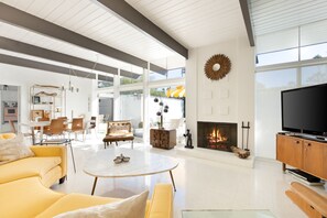 Mid-century designed living room with original gas fireplace and circular couch