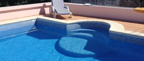 Piscine  avec des marches ou les enfants peuvent s' assoir très agréable  .