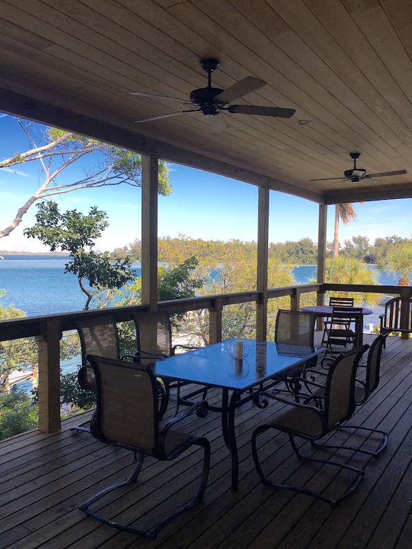 Covered terrace with table seating 6, two chairs and couch for enjoying the view