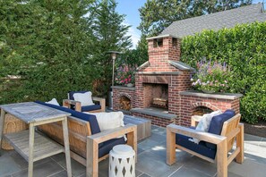 Outdoor living room with wood burning fireplace - bluestone patio