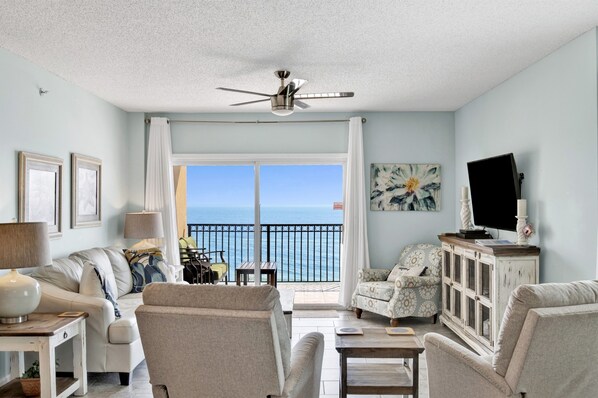 Living room features glass sliding doors leading to balcony, sleeper sofa & 2 recliners