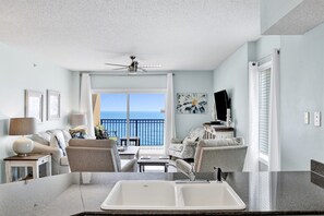 Living room features glass sliding doors leading to balcony, sleeper sofa & 2 recliners