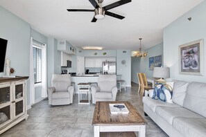 Living room features glass sliding doors leading to balcony, sleeper sofa & 2 recliners