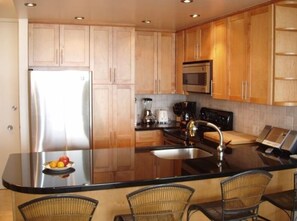 Pink Plumeria's sparkling kitchen with black granite countertop and marble floor