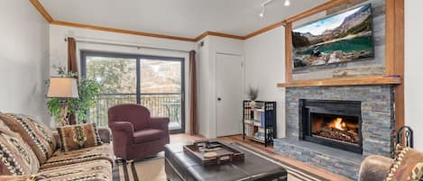 Living room with stacked slate fireplace and smart TV