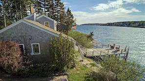 Side of cottage with view of deck and water