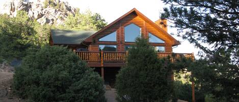Mountain luxury getaway surrounded by pines and rock outcroppings.