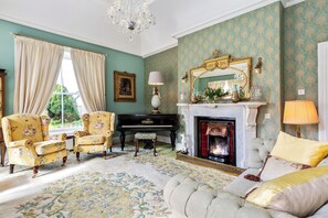 Drawing room with vaulted ceiling , Waterford chandelier , open fireplace.