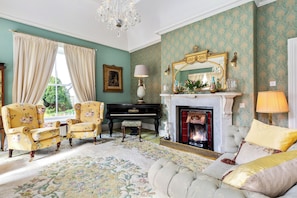 Drawing room with vaulted ceiling , Waterford chandelier , open fireplace.