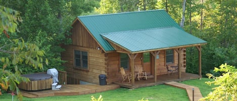 View of our Lazy Creek Cabin nestled in the woods with the creek behind it.